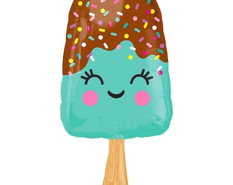 May include: A turquoise blue popsicle with a chocolate topping and sprinkles. The popsicle has a smiling face with pink cheeks and eyelashes. The popsicle is on a wooden stick.