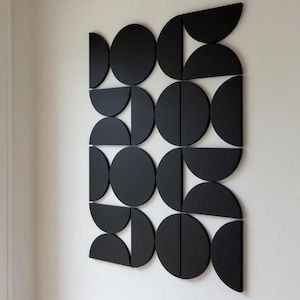 May include: A white ceramic mug with a black handle and the text "But First, Coffee" in a bold, black font. The mug is set against a blurred background, suggesting a cozy setting.