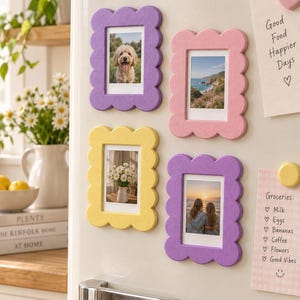 Peut inclure: Quatre cadres photo magnétiques rectangulaires aux bords festonnés en violet, rose et jaune. Les cadres contiennent de petites photos verticales d'un chien, d'un paysage côtier, d'un vase de fleurs et de deux personnes devant un coucher de soleil.