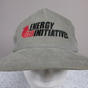 May include: A gray corduroy baseball cap with a red and black embroidered logo that says "ENERGY INITIATIVES".