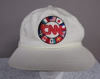 Boné vintage autêntico da CNN International com fecho de pressão, estilo "dad hat", usado em transmissões de notícias em Atlanta, Geórgia, nos anos 1990. Fabricado nos EUA.