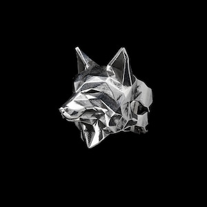 May include: A silver ring with a geometric wolf head design. The ring is made of metal and has a polished finish.