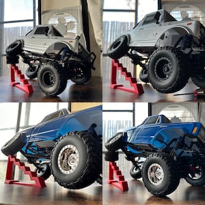 May include: Two toy trucks, one white and one blue, are positioned on red plastic ramps. The trucks are both lifted off the ground, with the front wheels on the ramps and the rear wheels in the air. The trucks are both detailed with realistic features, including tyres, headlights, and grilles.