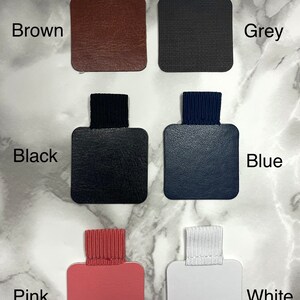 Puede incluir: Colección de portalápices en varios colores: marrón, gris, negro, azul, rosa y blanco. Cada uno tiene una base cuadrada con una banda elástica a juego y una etiqueta de color.