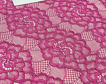 Puede incluir: Tela de encaje floral magenta con un patrón delicado. La tela tiene un pequeño diseño floral repetitivo con un fondo en forma de cuadrícula. La tela es suave y transparente, y sería perfecta para una variedad de proyectos, como ropa, accesorios y decoración del hogar.