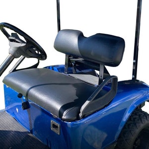 May include: A blue golf cart with a black leather seat and a black headrest. The cart has a black steering wheel and a black roll bar.