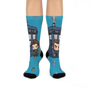 May include: A pair of blue socks with a Doctor Who theme. The socks feature a blue police box, Daleks, and the Doctor. The text "Police Box" is printed on the police box.