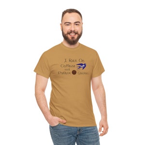 Könnte beinhalten: Ein braunes T-Shirt mit dem Text "I Run On Caffeine and Python Quotes" und einem blauen Vogel mit einem braunen Ball im Schnabel.