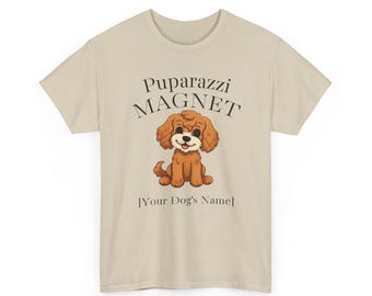 Może przedstawiać: Jasnobrązowy t-shirt z napisem "Puparazzi MAGNET" i ilustracją brązowego psa. Poniżej znajduje się tekst "[Your Dog's Name]" w kolorze czarnym. Koszulka ma okrągły dekolt.
