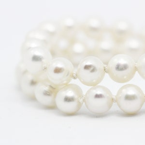 May include: A white pearl bracelet with a gold clasp.