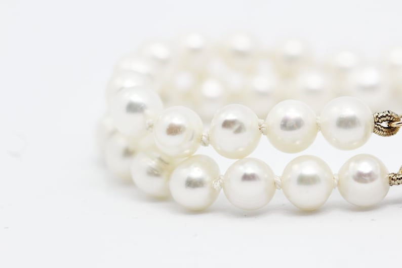 May include: A white pearl bracelet with a gold clasp.