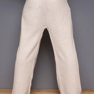 May include: A pair of off-white linen pants with a wide waistband and a loose, flowing fit. The pants are designed for yoga, tai chi, and other forms of exercise. The text "ZEMNA YOGA FLOWER & TAI CHI MASALA SERIES" is printed on the bottom of the image.