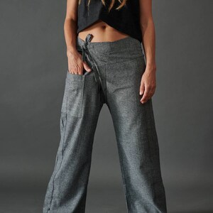 May include: Gray wrap pants with a tie at the waist. The pants have a large pocket on the left side.