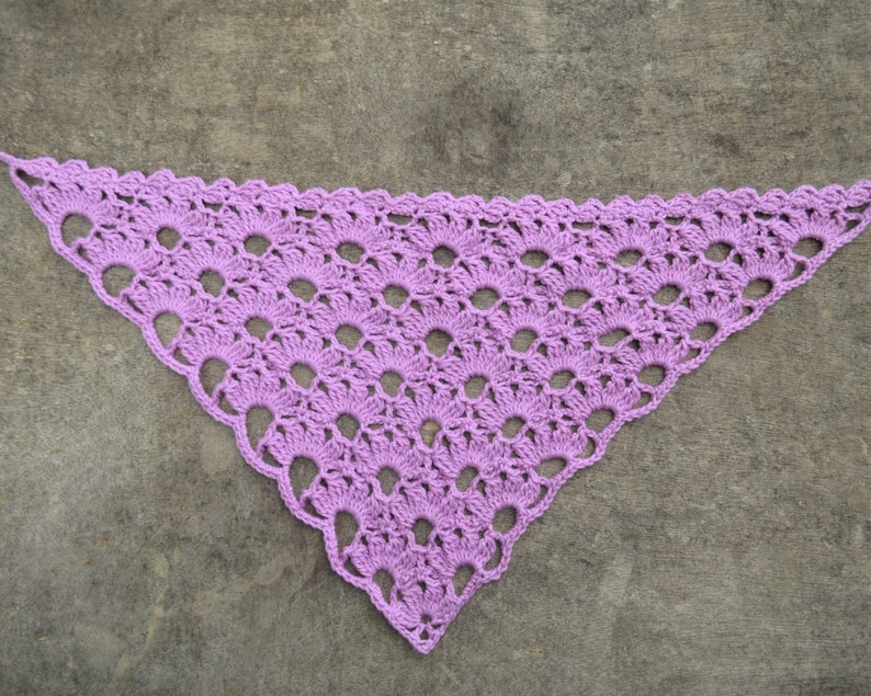 May include: A purple crocheted triangular shawl with a lacy pattern.