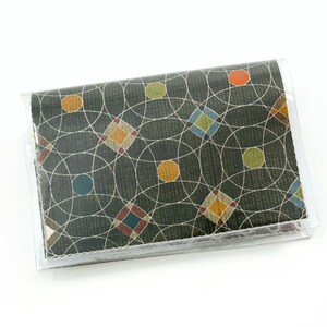 May include: A green and brown wallet with a geometric pattern of circles, squares, and diamonds. The wallet has a clear plastic cover.