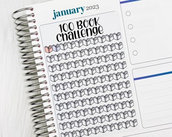 May include: A white sticker with the text "January 2023 100 Book Challenge" and a grid of 100 book icons. Two of the icons are colored in pink and blue.