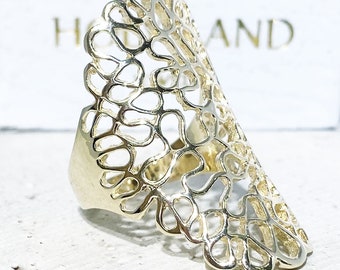 May include: Gold ring with a delicate, intricate design resembling a branch of coral. The ring is open and has a wide band.