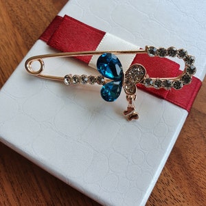 Butterfly clear diamante safety pin brooch with turquoise gems.