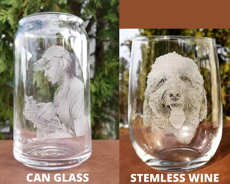 Puede incluir: Dos vasos de vidrio transparente con grabados personalizados. El primer vaso es un vaso con forma de lata con la cara de un hombre grabada en &eacute;l. El segundo vaso es un vaso de vino sin tallo con la cara de un perro grabada en &eacute;l.