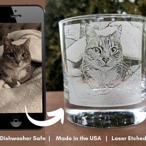 May include: A clear glass tumbler with a laser etched image of a tabby cat. The cat is lying down on a blanket. The glass is dishwasher safe and made in the USA. "Laser Etched" is printed on the bottom of the image.