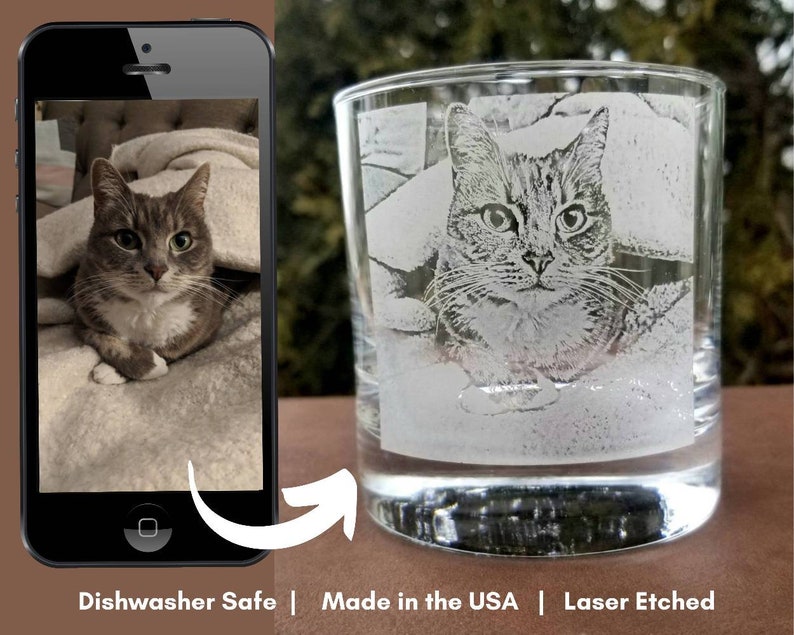 May include: A clear glass tumbler with a laser etched image of a tabby cat. The cat is lying down on a blanket. The glass is dishwasher safe and made in the USA. "Laser Etched" is printed on the bottom of the image.