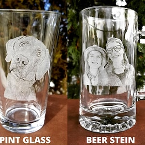 Puede incluir: Dos opciones de vasos de bebida de vidrio personalizados: un vaso de pinta con la cara de un perro grabada y un jarro de cerveza con una foto de pareja grabada.