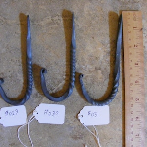 May include: Three hand-forged metal hooks with a twisted design. The hooks are labeled #029, #030, and #031.