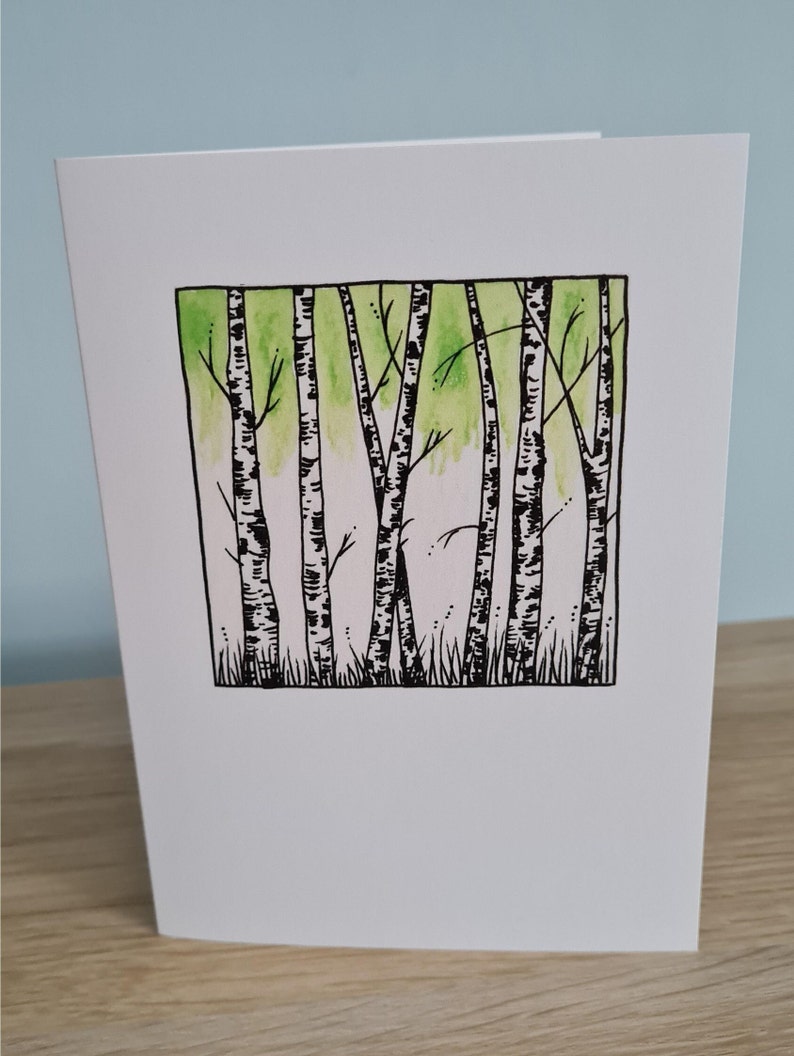 Puede incluir: Una ilustraci&oacute;n en blanco y negro de un bosque de abedules con un lavado de acuarela verde en el fondo.