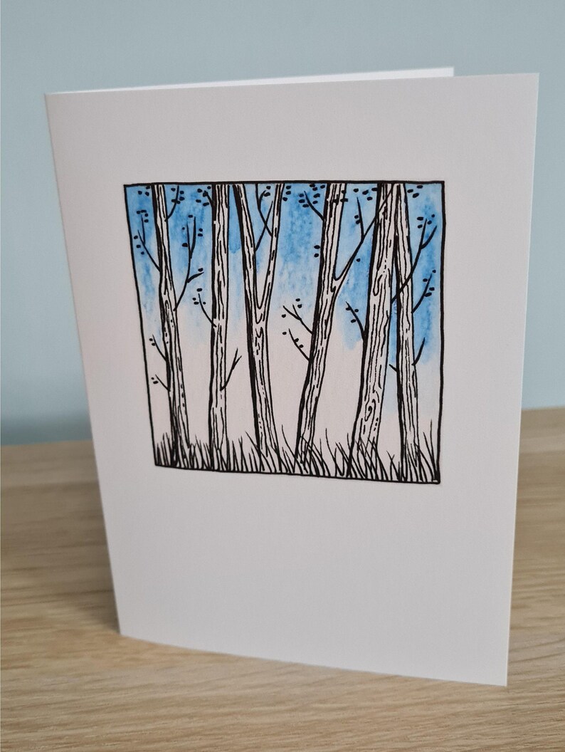 Puede incluir: Una ilustraci&oacute;n en blanco y negro de un bosque con un fondo de acuarela azul. Los &aacute;rboles son altos y delgados con ramas que se extienden hacia el cielo.