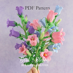 May include: A hand holds a bouquet of beaded flowers in pink, blue, and purple. The flowers have green stems and leaves. The image includes the text "PDF Pattern" and "Bead & Blossom by Lauren Harpster."