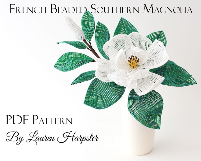 May include: A white beaded Southern Magnolia flower with green leaves in a white vase. The flower is made with white beads and the leaves are made with green beads. The flower is in a white vase. The image includes the text "French Beaded Southern Magnolia" and "PDF Pattern By Lauren Harpster".