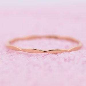 Op de afbeelding: Een eenvoudige, delicate gouden ring met een golvende, getextureerde band.