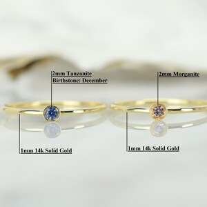 May include: Two gold rings with a 2mm tanzanite birthstone for December and a 2mm morganite gemstone. Both rings are 1mm 14k solid gold.
