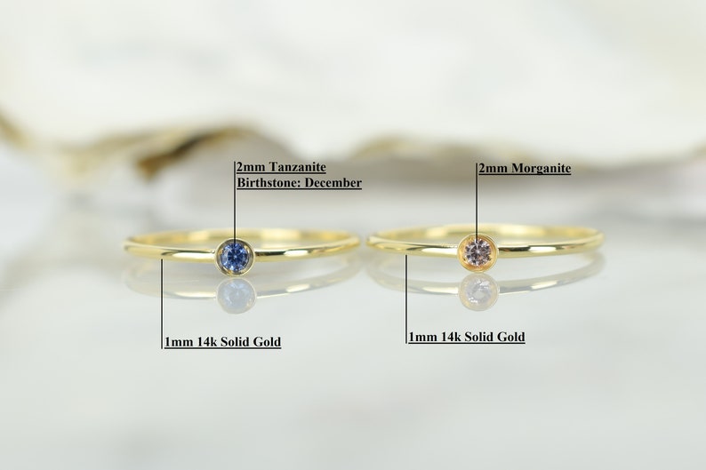 May include: Two gold rings with a 2mm tanzanite birthstone for December and a 2mm morganite gemstone. Both rings are 1mm 14k solid gold.