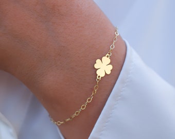 May include: A gold chain bracelet with a four-leaf clover charm.