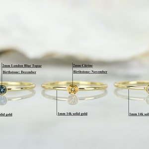 May include: Three gold rings with different colored gemstones. The rings are 1 mm wide and made of 14k solid gold. The gemstones are 2 mm in diameter. The first ring has a blue topaz, the second ring has a citrine, and the third ring has a sky blue topaz.
