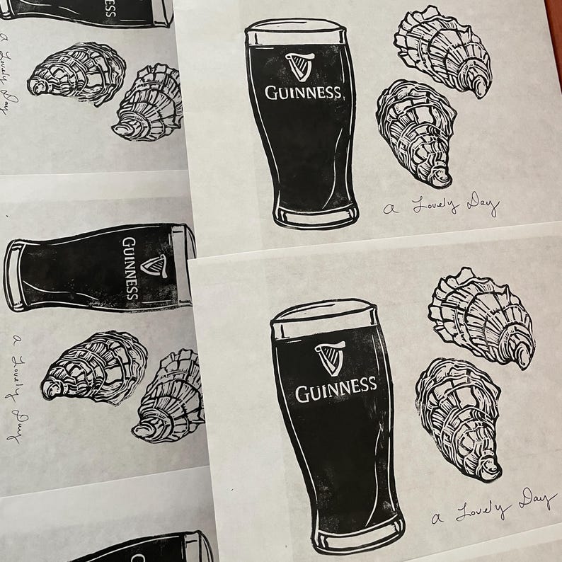 Pu&ograve; includere: Quattro illustrazioni in bianco e nero di un bicchiere di birra Guinness e ostriche. Il testo "GUINNESS" &egrave; stampato sul bicchiere. Il testo "a lovely day" &egrave; scritto a mano su ogni illustrazione.