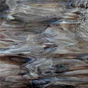 May include: Abstract stained glass with a flowing, marbled appearance. The glass features a blend of brown, gray, and white hues, creating a dynamic, textured effect. The design evokes a sense of movement and depth, suitable for decorative applications.