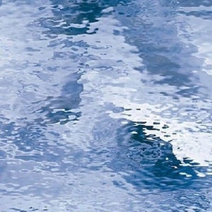 May include: Abstract image of water with a rippled surface. The water has a light blue color with darker blue reflections, creating a sense of depth and movement. The overall effect is one of tranquility and natural beauty.