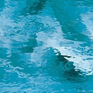 May include: Abstract image of rippling water in shades of blue and turquoise. The surface reflects light, creating a dynamic pattern of waves and highlights. The overall effect is a serene and fluid visual texture.