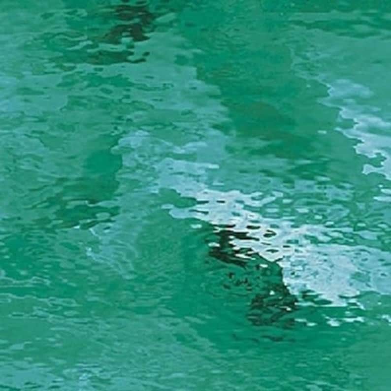 May include: An abstract image showing the surface of water in shades of teal and green. The water ripples, creating a textured pattern with areas of light and dark. The image evokes a sense of depth and movement.