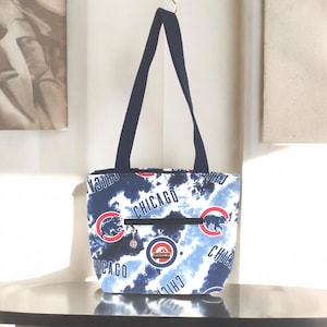 Bolso de mano de los Chicago Cubs, bolsillo exterior delantero con cremallera, bolsillo interior con cremallera, tres bolsillos deslizantes, llavero extraíble, dije de los Cubs, cierre a presión.
