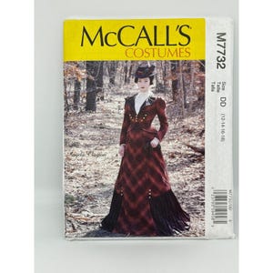May include: A McCall's Costumes sewing pattern featuring a woman in a red and black plaid dress with gold buttons. The pattern is labeled M7732, size DD (12-14-16-18), and includes the designer's name, Angela Clayton.