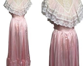 May include: A vintage pink satin dress with a high neckline and a lace overlay. The dress features a ruffled hem and a fitted bodice. The lace overlay is white and adds a delicate touch to the dress. The dress is a full-length gown.