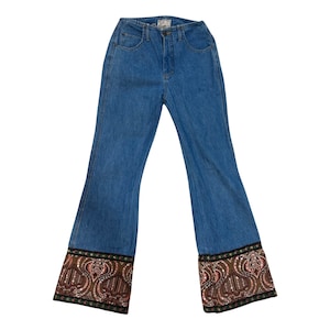 May include: Blue denim bell bottom pants with a paisley patterned trim around the bottom of the legs.