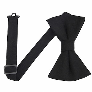 May include: A black bow tie with an adjustable strap. The bow tie is made of a soft, textured fabric.