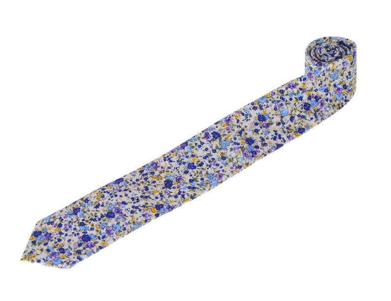 May include: A white tie with a blue and yellow floral pattern.