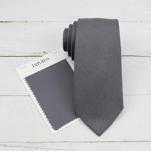 May include: A gray necktie with a fabric swatch labeled "Pewter" from David's Bridal.