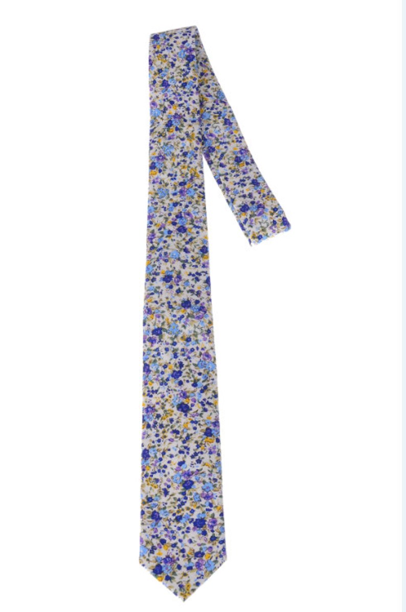 May include: A white tie with a blue and yellow floral pattern. The tie is made of a soft, comfortable fabric and is perfect for adding a touch of style to any outfit.