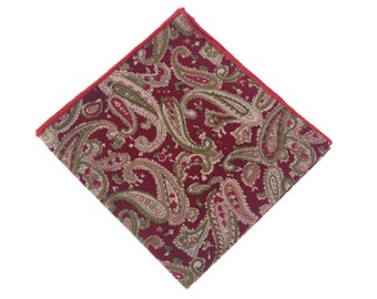 May include: A red paisley pocket square with a green and white pattern. The pocket square has a red border.